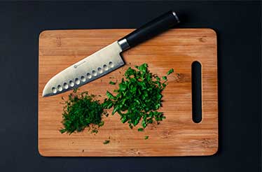 knife wood board and herbs